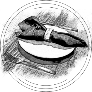 A cloth napkin wrapped with a "PRIMUS" label sits on a white plate with a fork beside it on a wooden table.