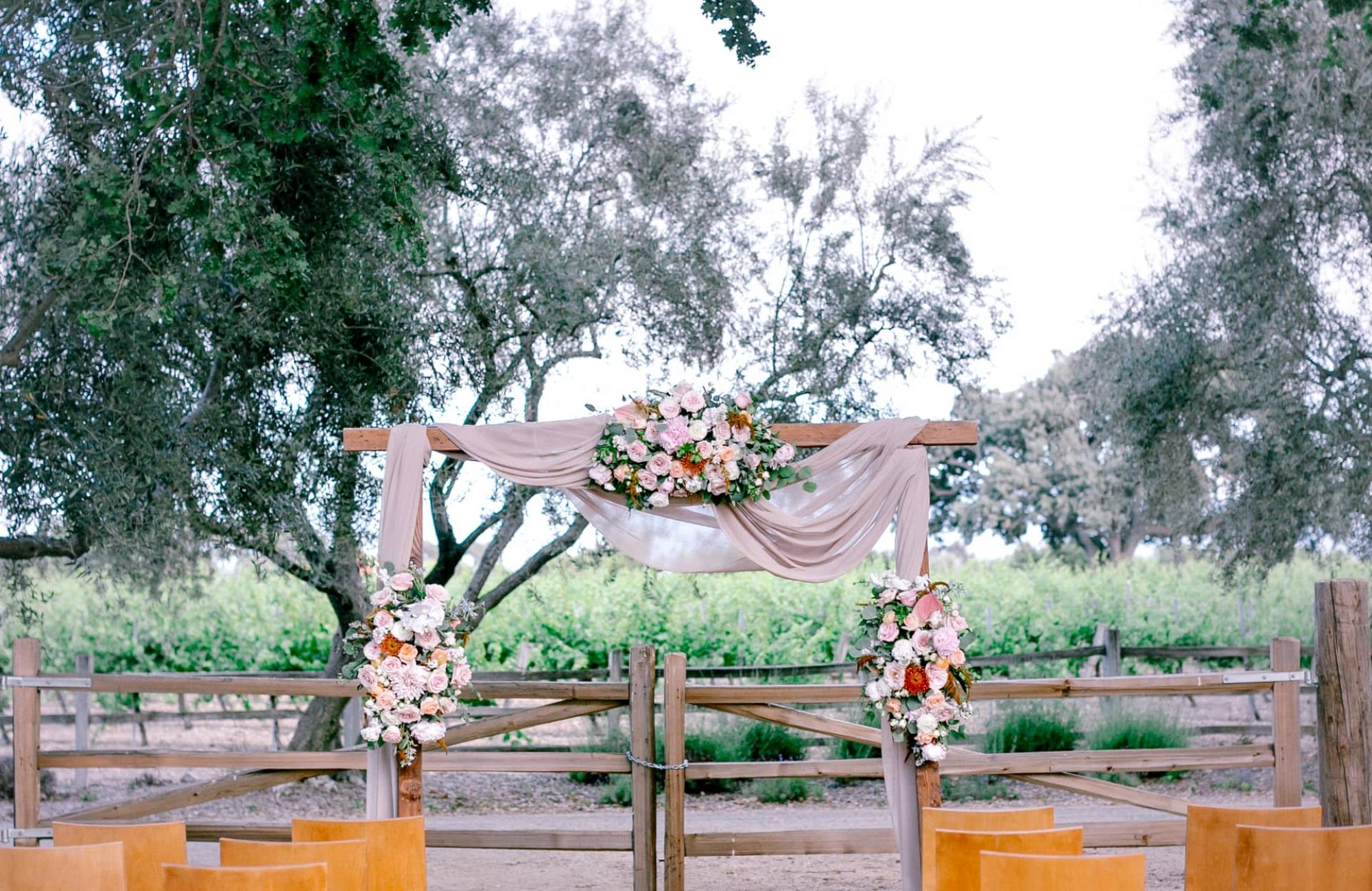 Outdoor Reception Area with Chairs, Flower Arrangements & Archway at Petros Winery