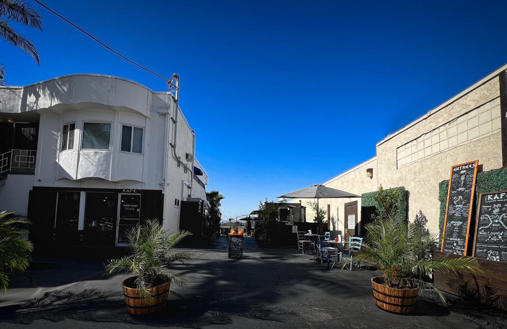 Exterior wide shot of Petros Kafe with trees and tables