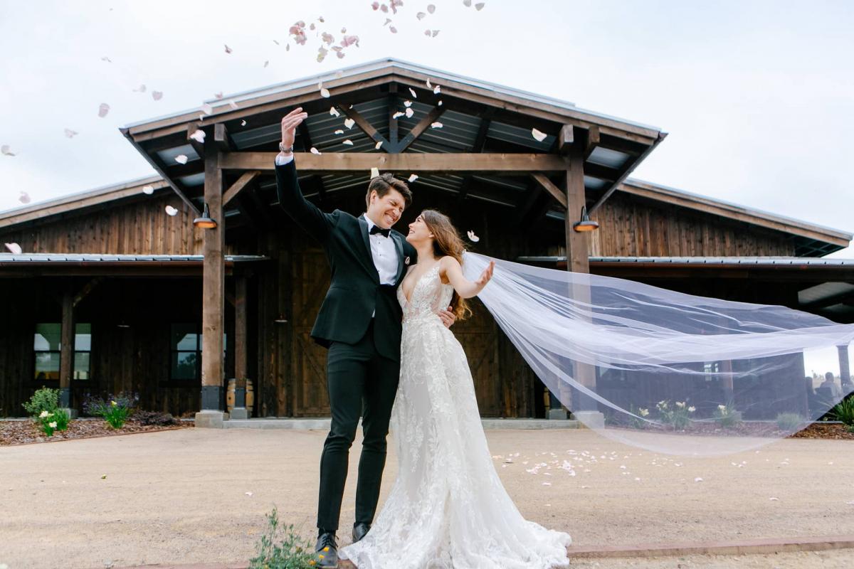 Bride & Groom with Flower Petals in Front of Petros Winery for Mika & James's Wedding