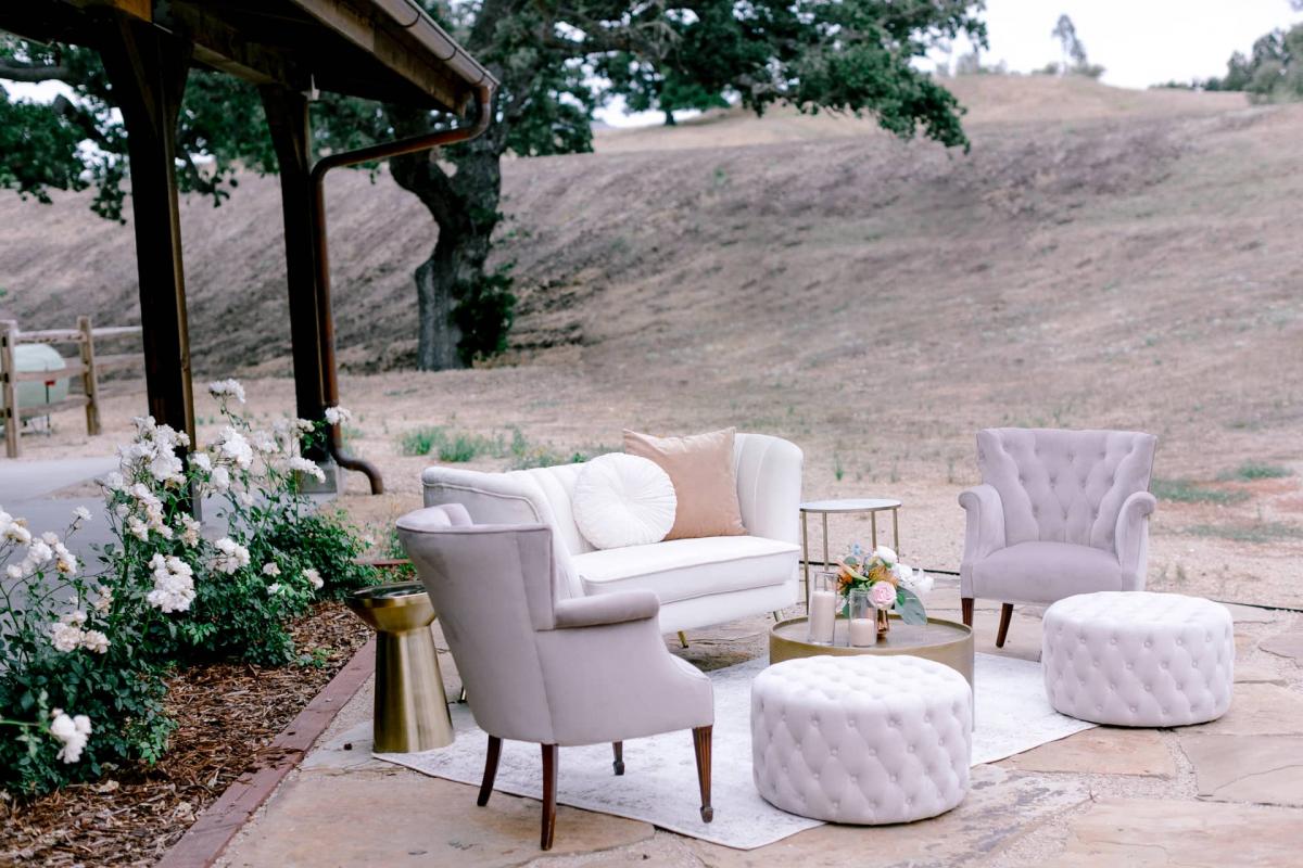 Outdoor Setting with Couch, 2 Chairs, Coffee Table and Poofs with Hills Behind for Mika & James's Wedding