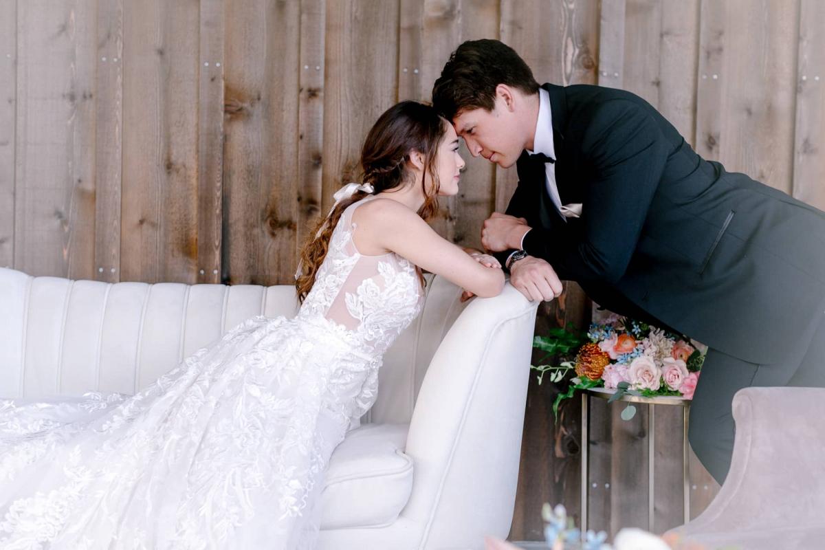 Bride Leaning Over Couch with Groom Touching Brides Head for Mika & James's Wedding