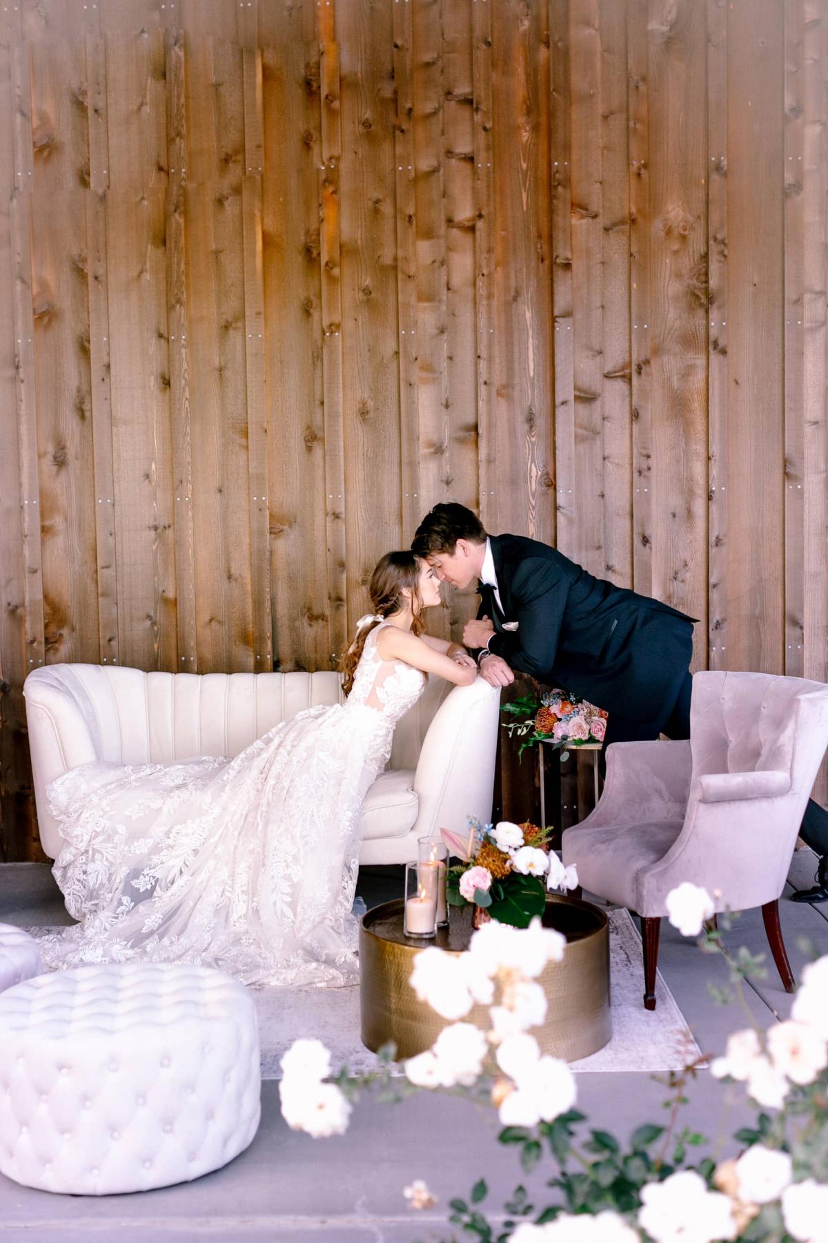 Wide View of Bride Leaning Over Couch with Groom Touching Brides Head for Mika & James's Wedding