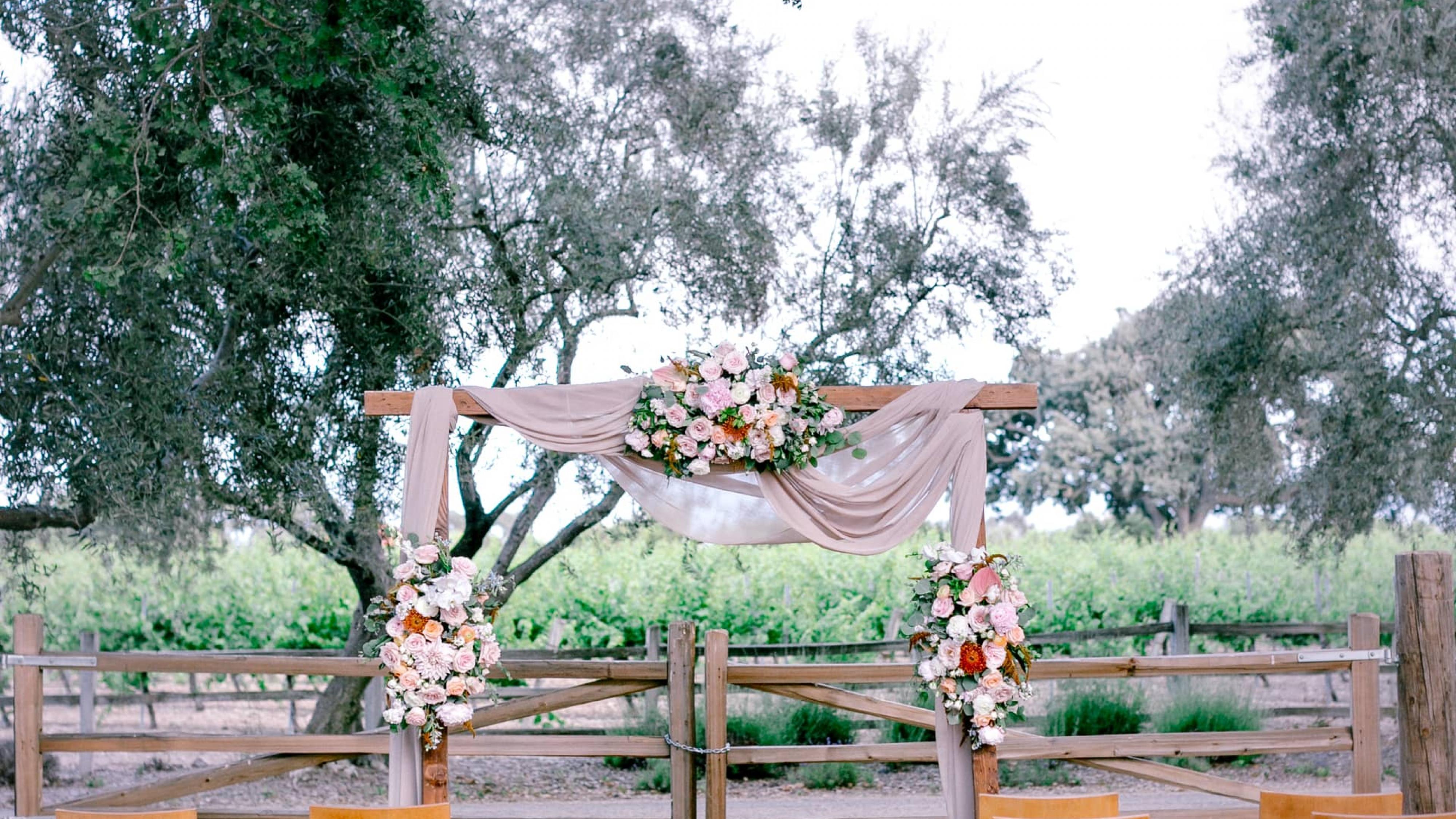 Outdoor Reception Area with Chairs, Flower Arrangements & Archway at Petros Winery